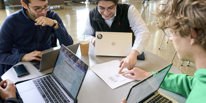 Sandro and other students sitting at a table with their laptops
