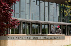 MIT Sloan students converse outside building E62.