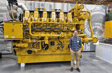 LGO student Santiago Andrade poses with machinery at Caterpillar in Lafayette, Indiana