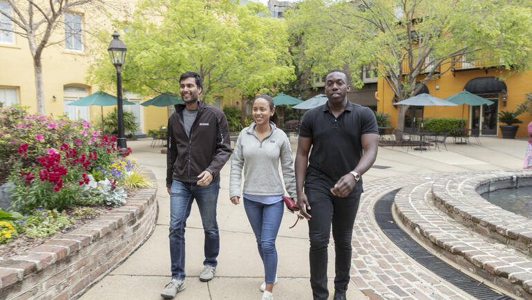 3 USA Lab students walking along a sidewalk in Charleston, SC. 