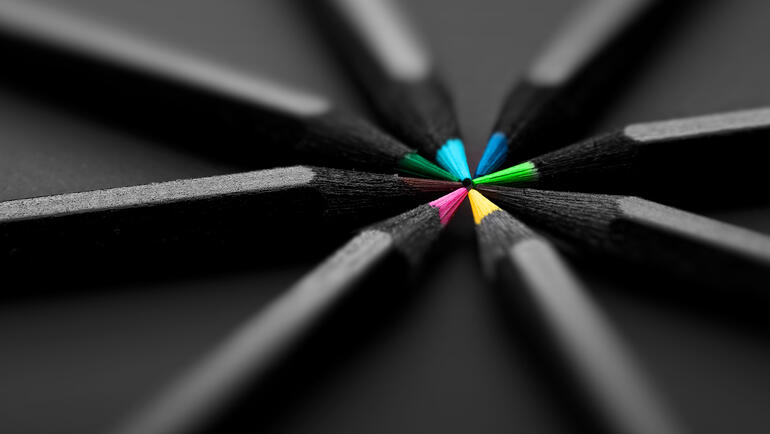 black pencils with colored points meet in a pinwheel