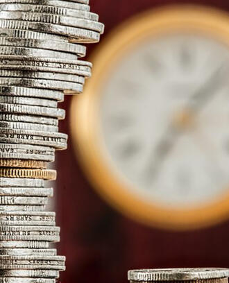 stacked coins with clock in background