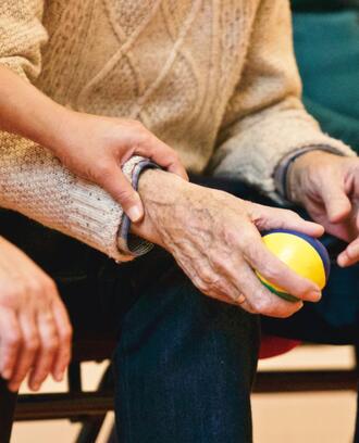 Person holding an elderly person's hand