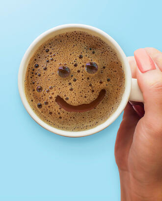 A happy face appears on a cup of coffee