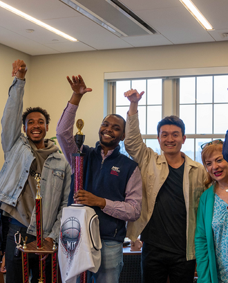 Interim Dean Georgia Perakis poses with MIT Sloan Basketball Club members and trophy