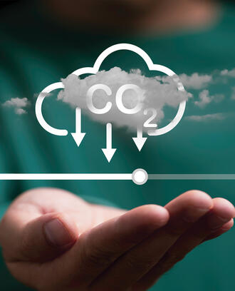 A person holds a decarbonization icon and loading bar for carbon emissions