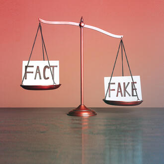 A justice scale has the word "Fact" on one side and "Fake" on the other.