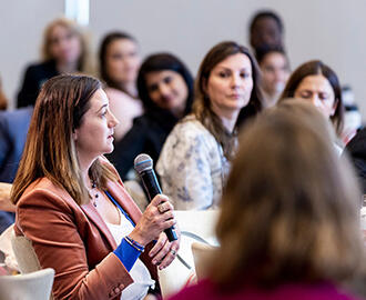 An MIT Sloan Women's Conference attendee asks a question during a session.