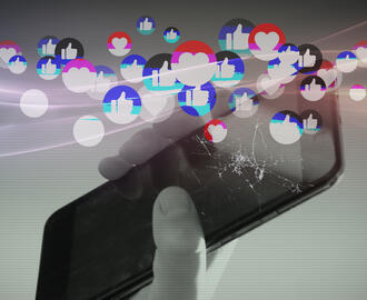A plethora of social media hearts and like buttons next to a cracked mobile phone