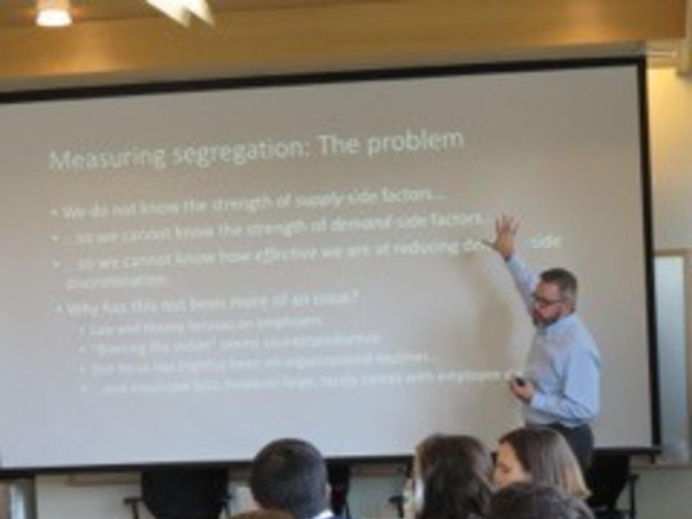 A photograph of a researcher presenting at one of the weekly IWER seminars at MIT Sloan.