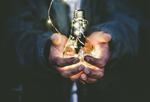 Light bulb lit up in hands.