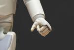 Image of white robotic hand on black background.