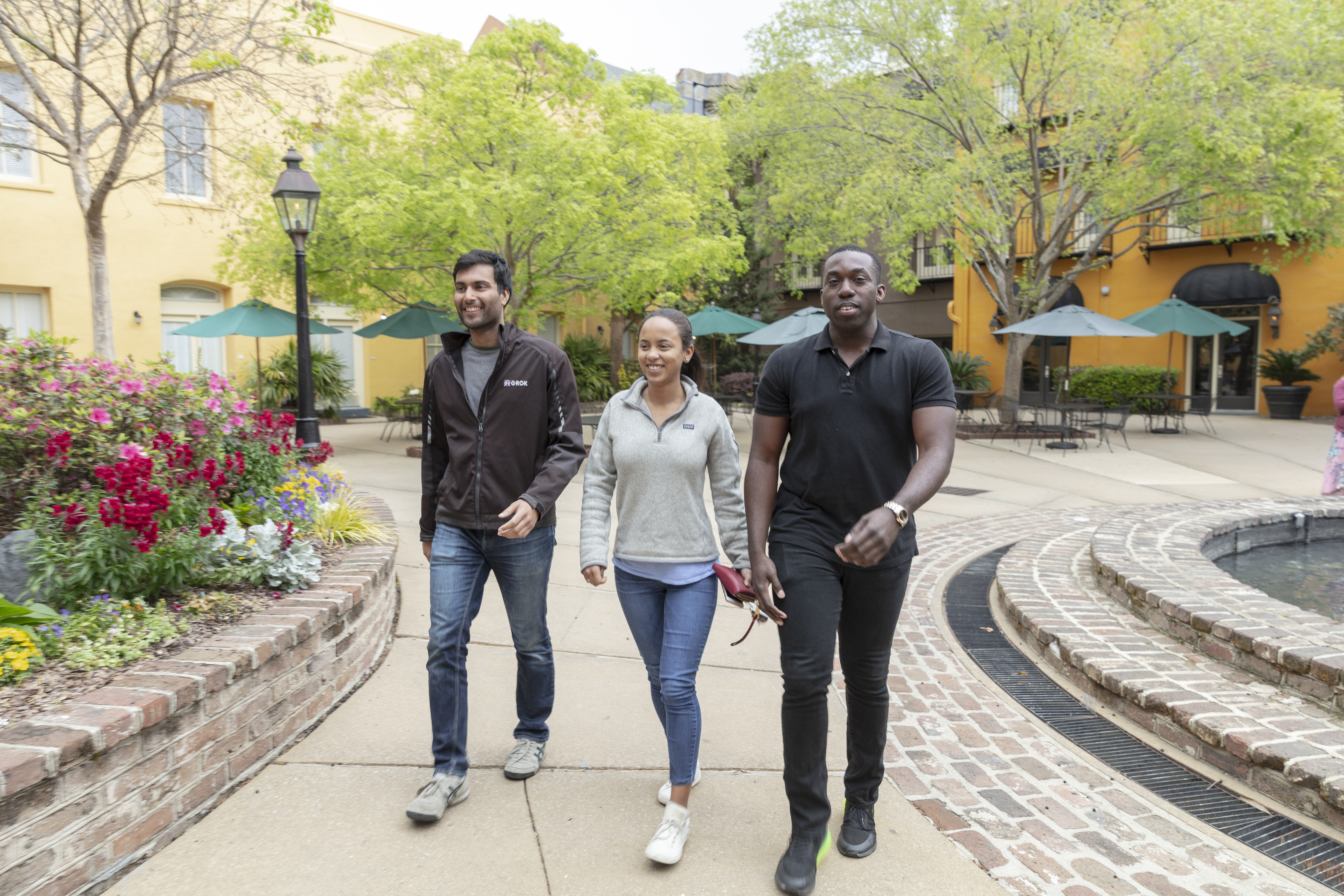 3 MBA students walking along a path in Charleston, SC