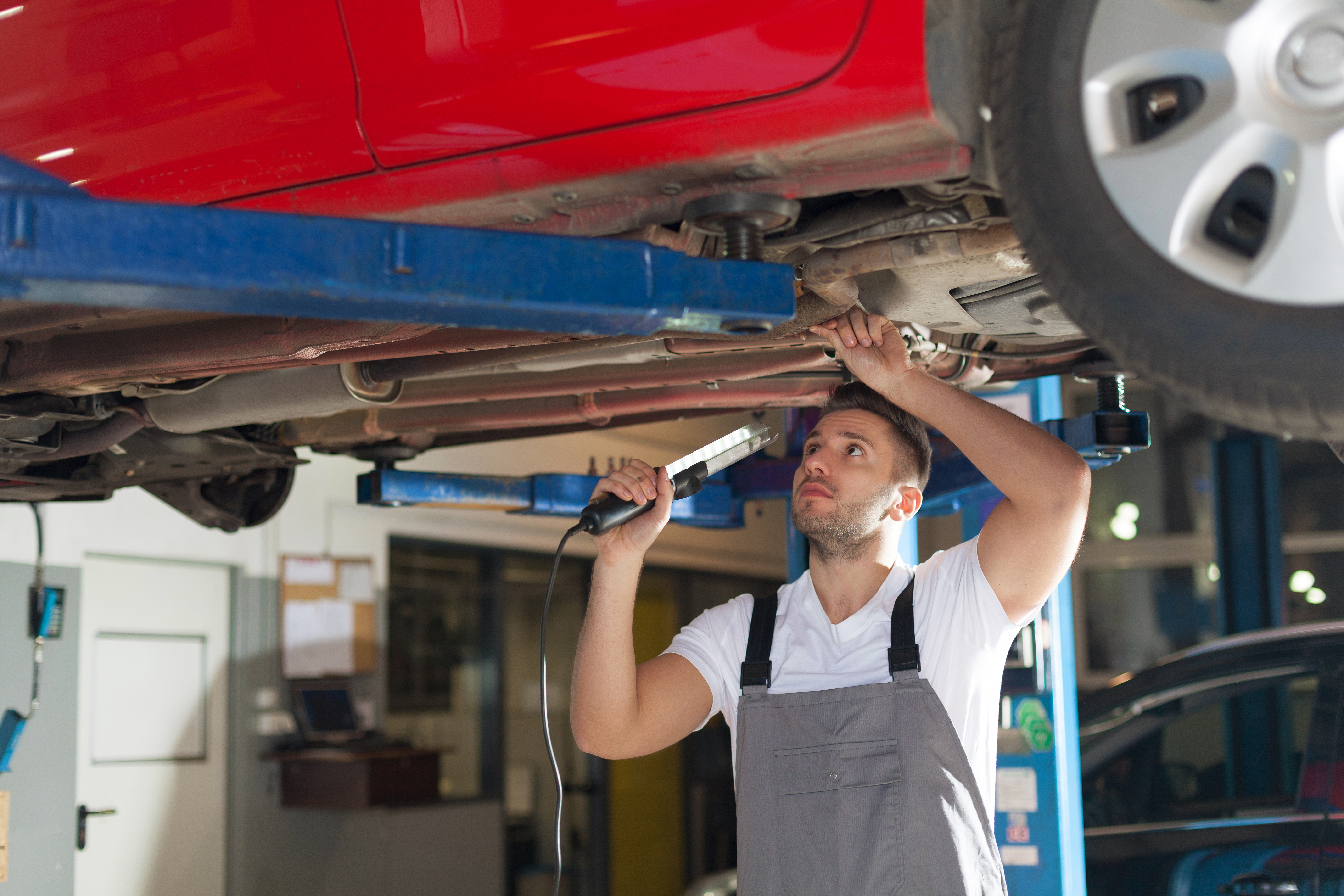 person standing underneath and fixing car