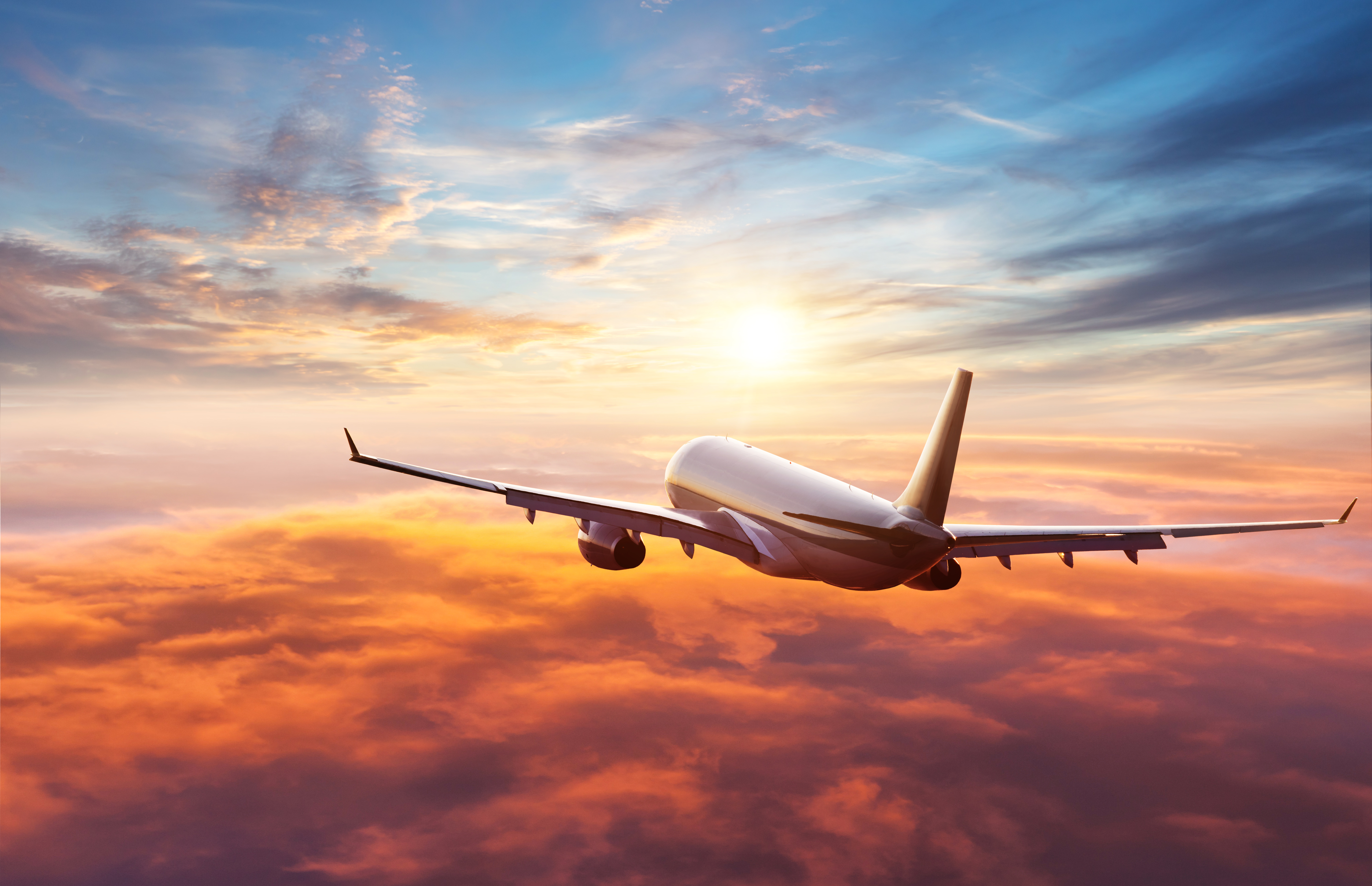airplane flying into sunset