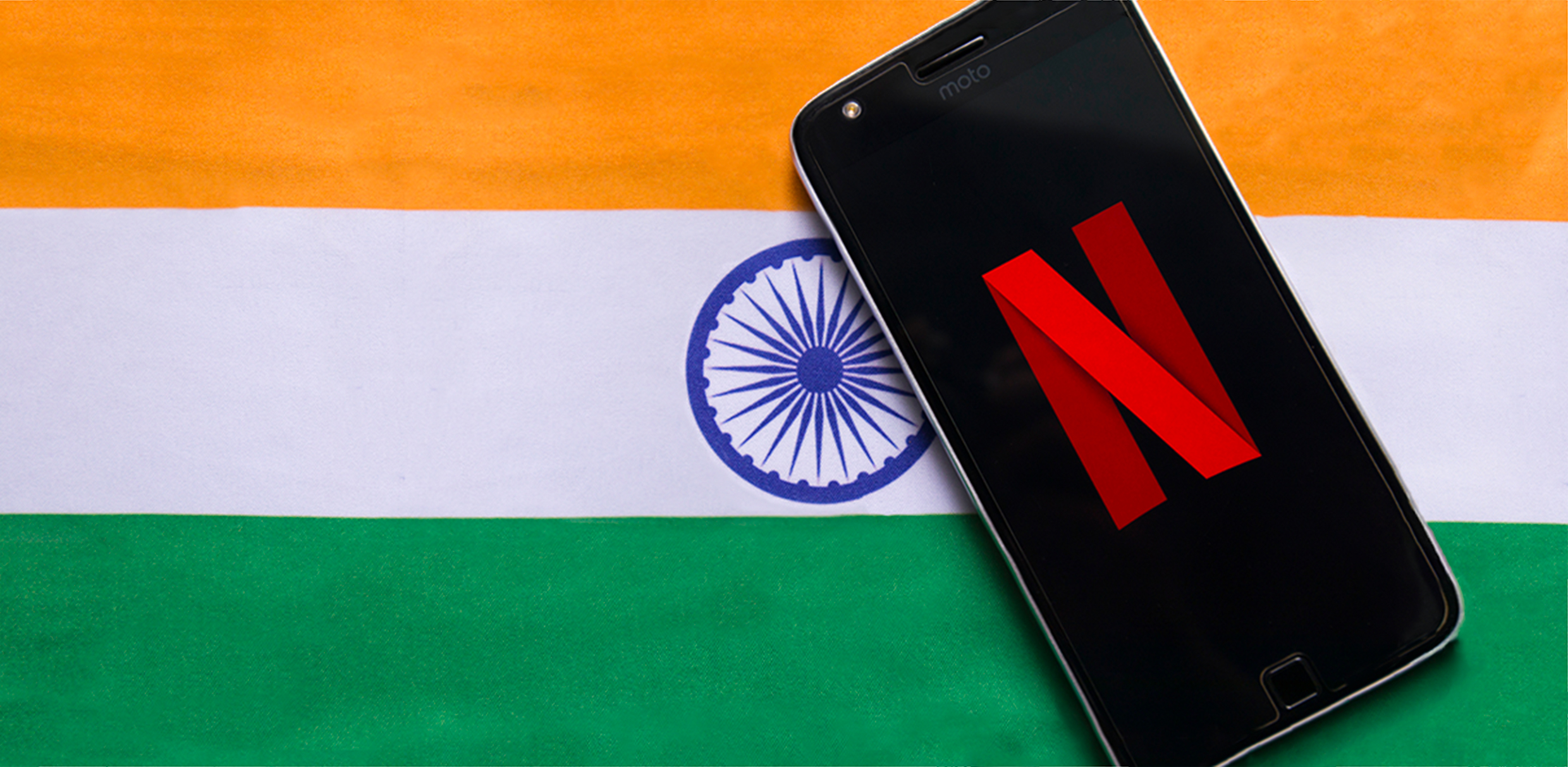 Cell phone with Netflix icon on top of an Indian flag