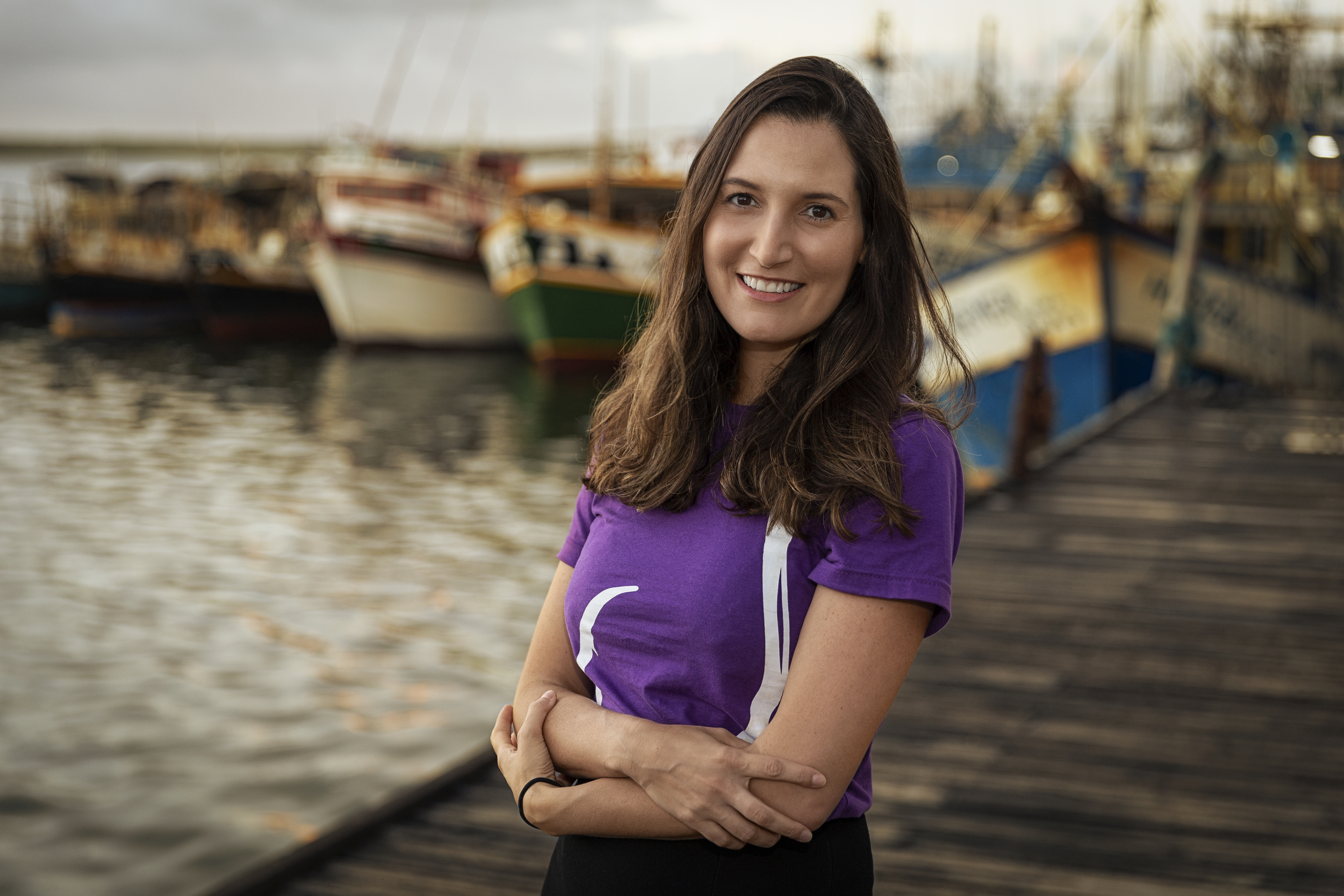 Portrait of Barbara Granek, alumni and CEO and founder of Fishtag on dock in front of fishing boats