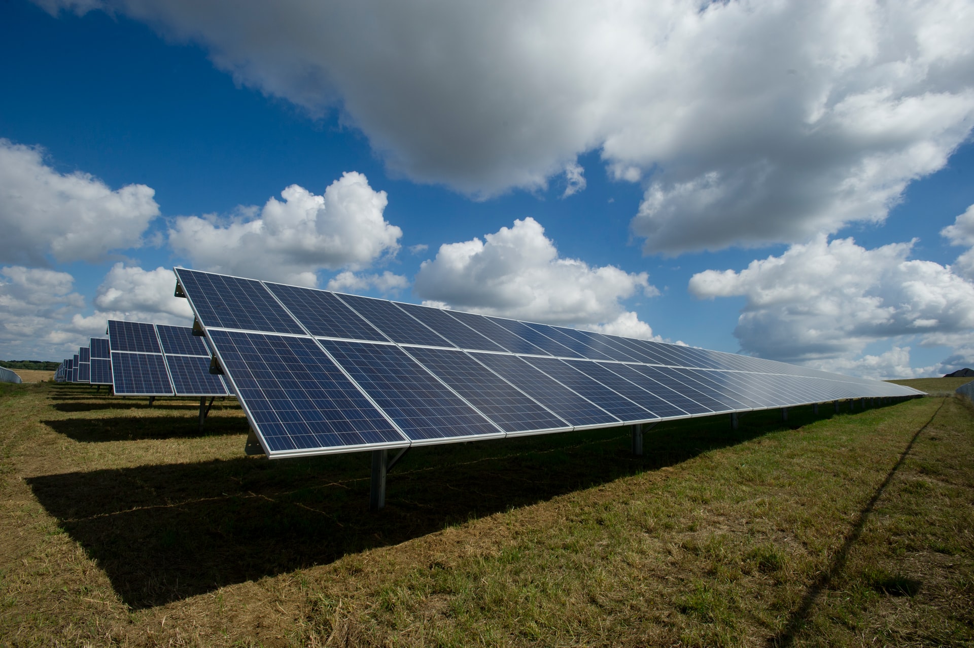 Solar panels in a field on a partly cloudy day
