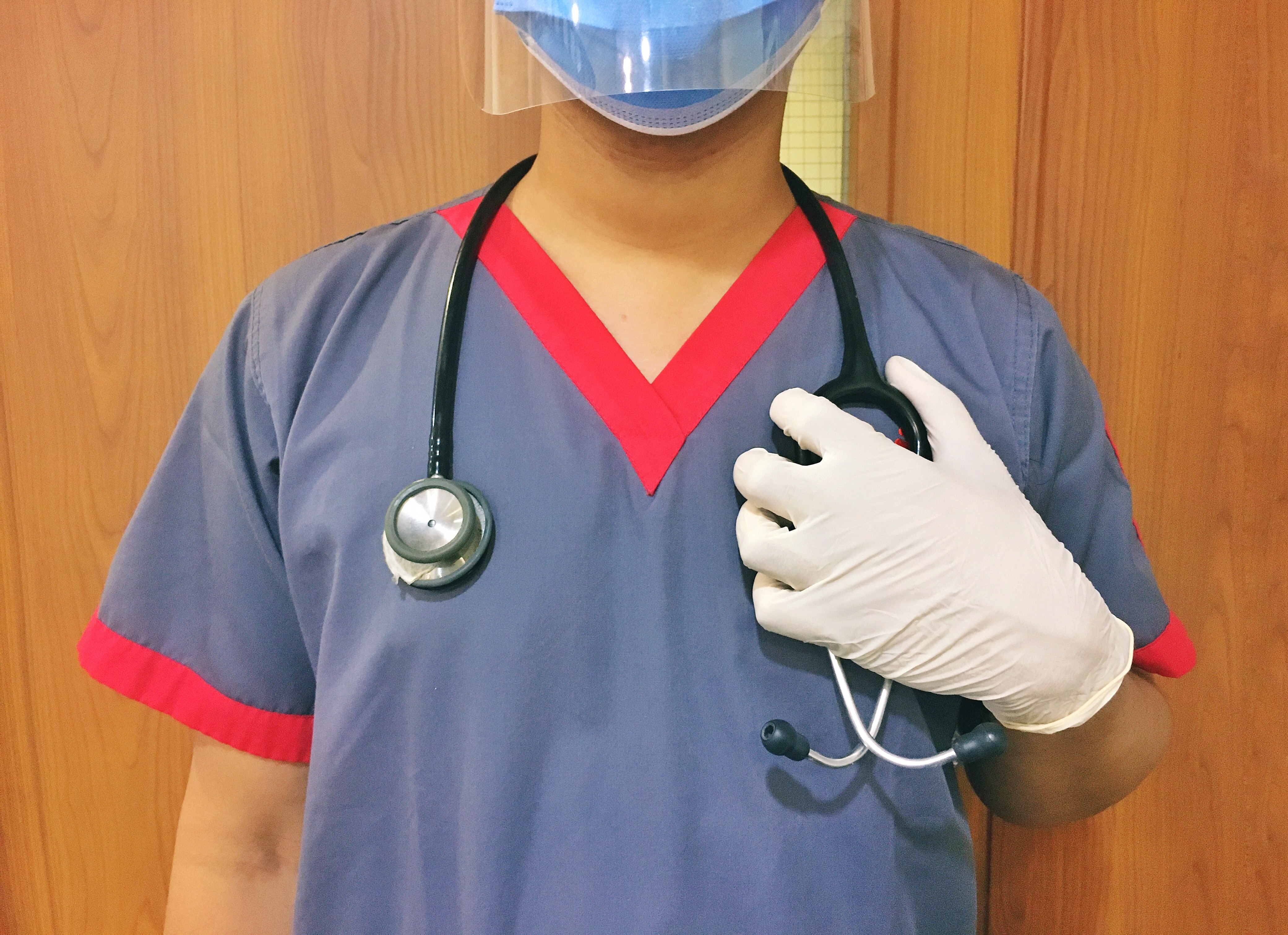 Nurse in face shield and mask with stethoscope draped over her shoulders