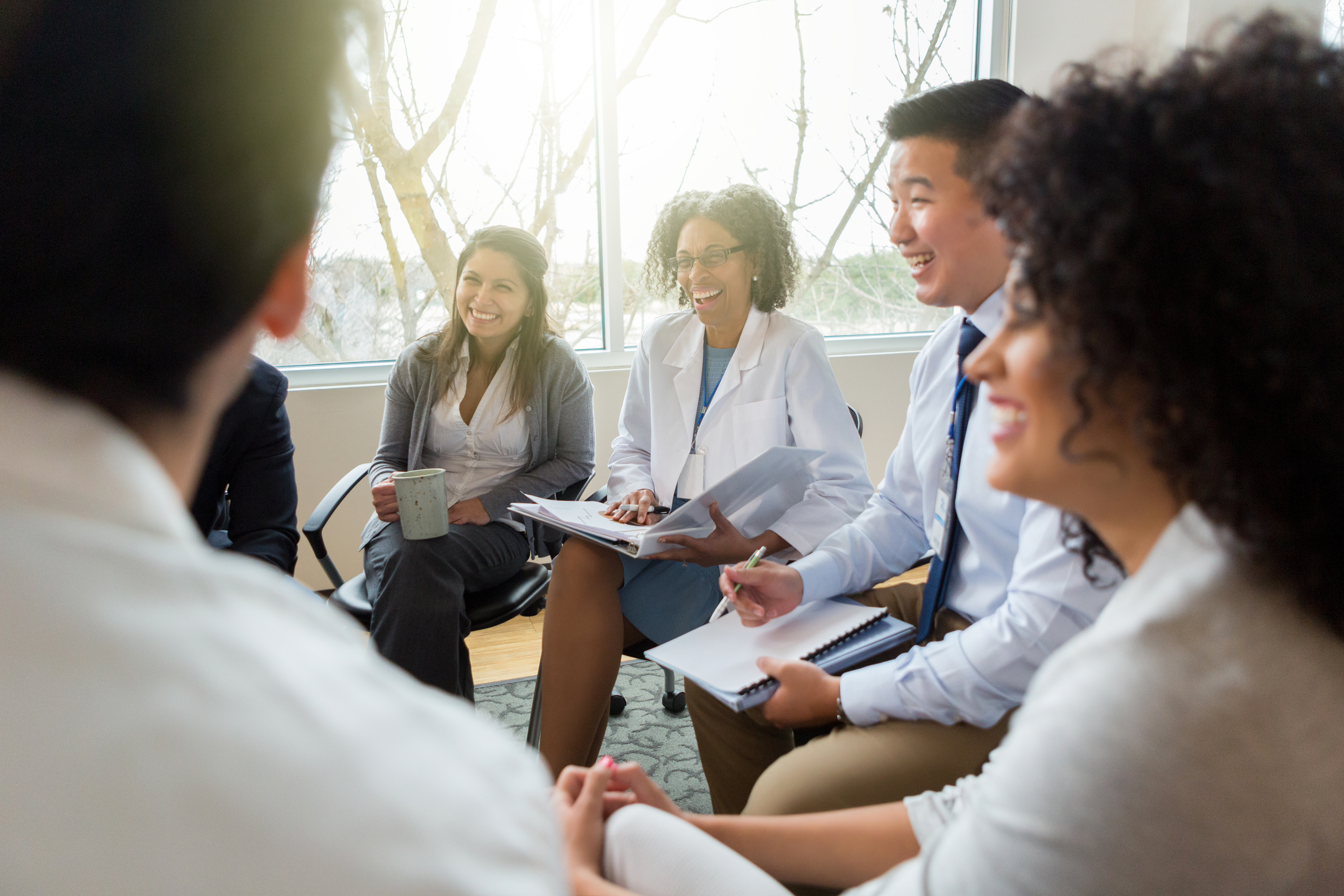 Group of health workers and designers seated in a circle discussing ideas