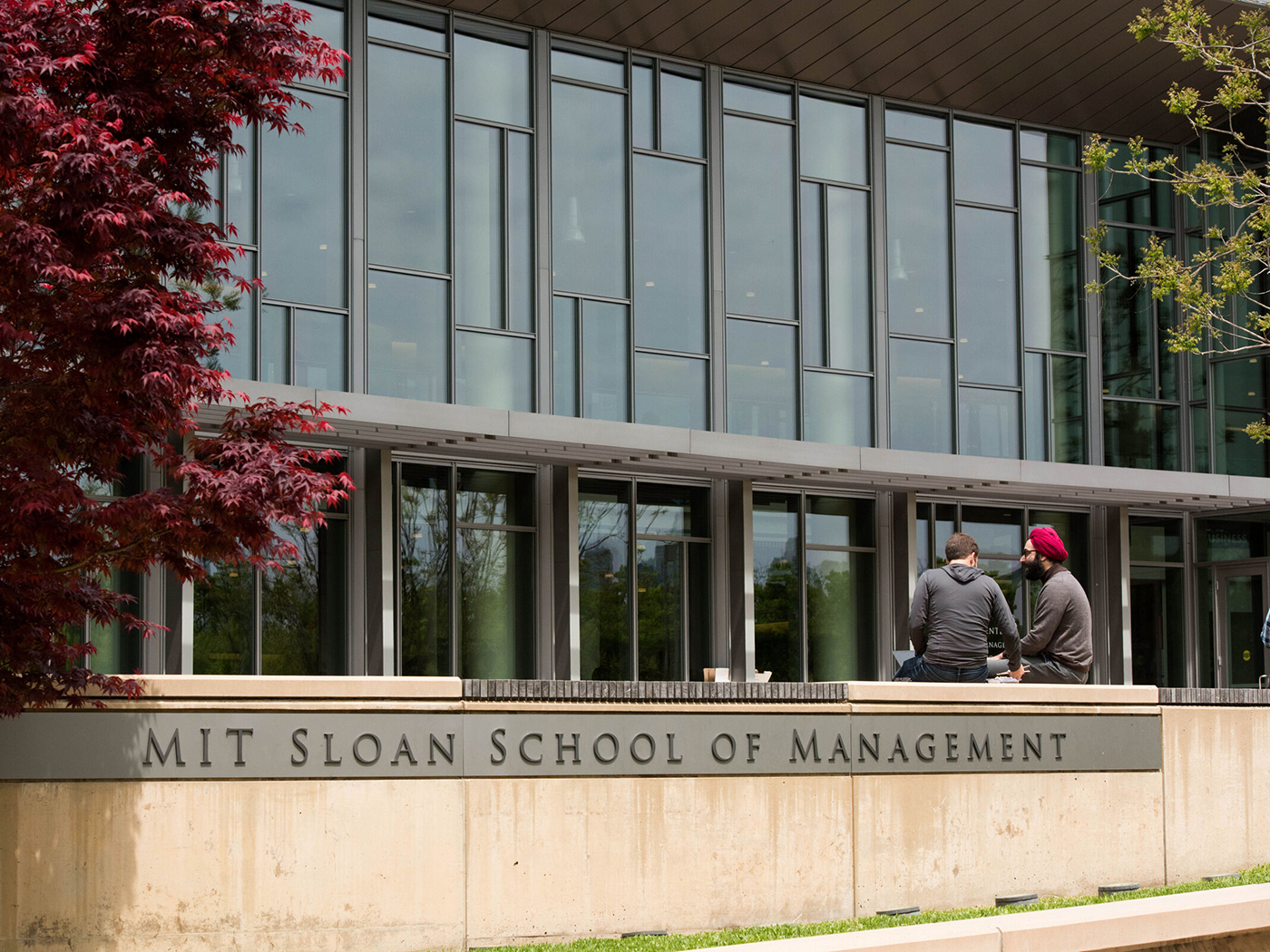 MIT Sloan students converse outside building E62.