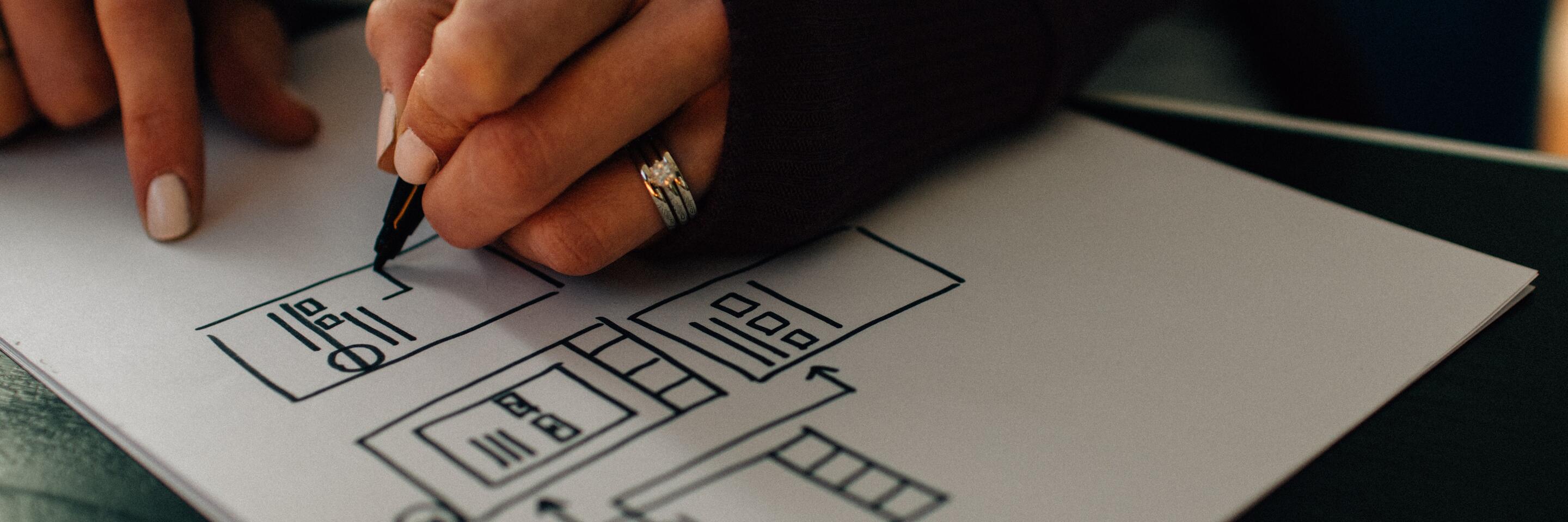 Photo of a person drawing website wireframe.