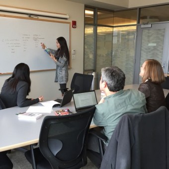 A small group of IWER PhD students, one of whom is writing on a whiteboard.
