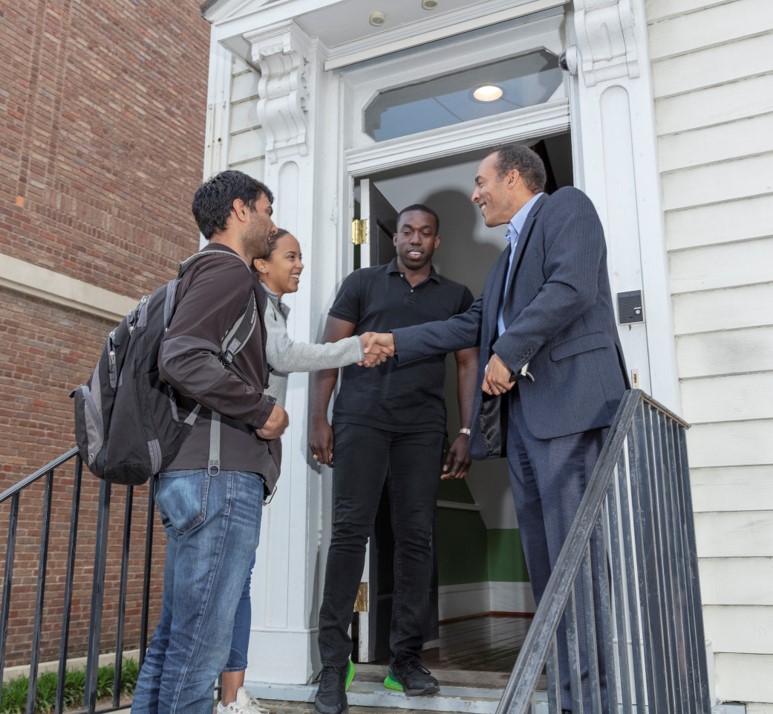 Three students from the USA Lab Class at MIT Sloan meeting with a community leader