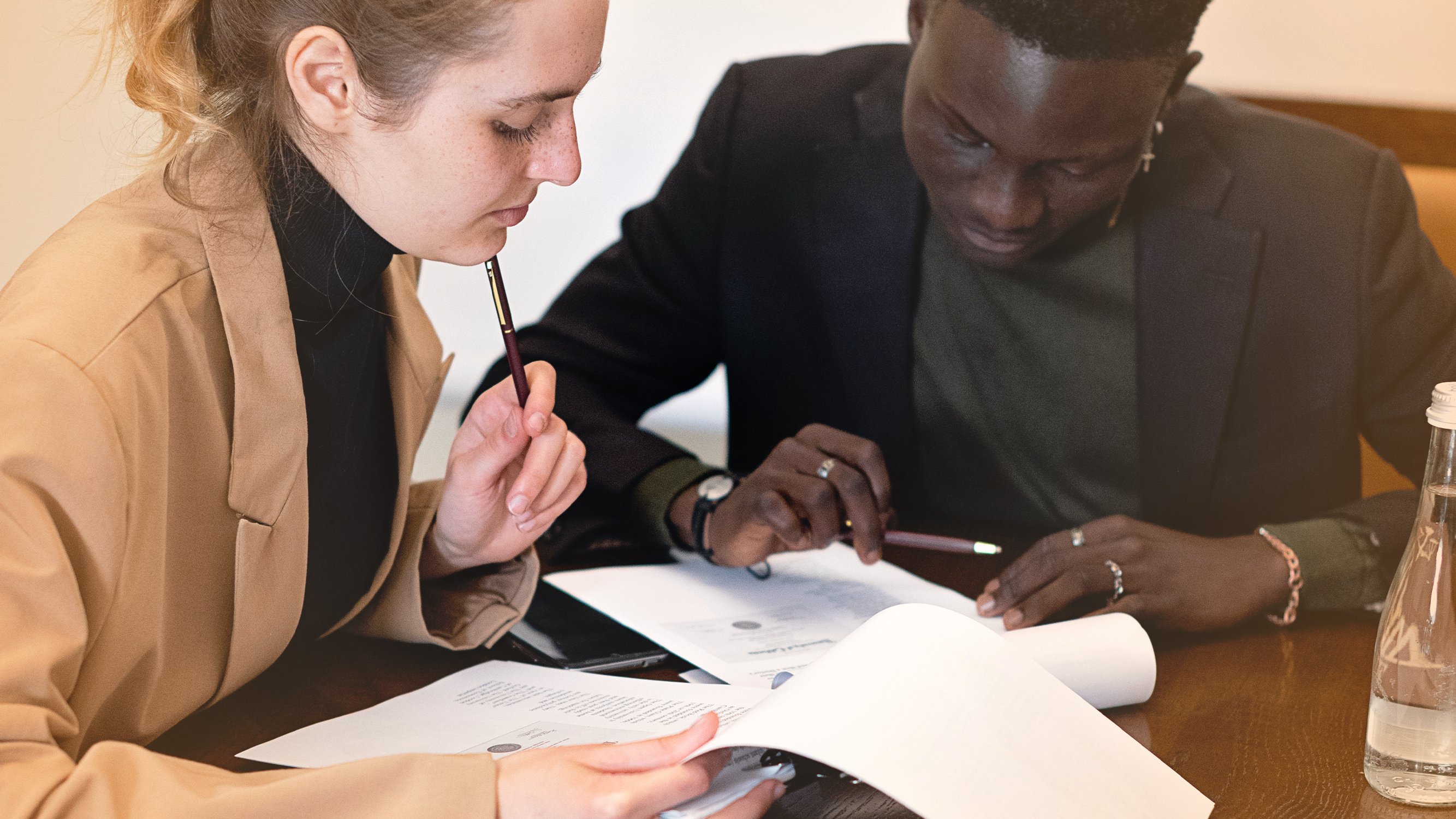 Two people at a table reviewing paperwork