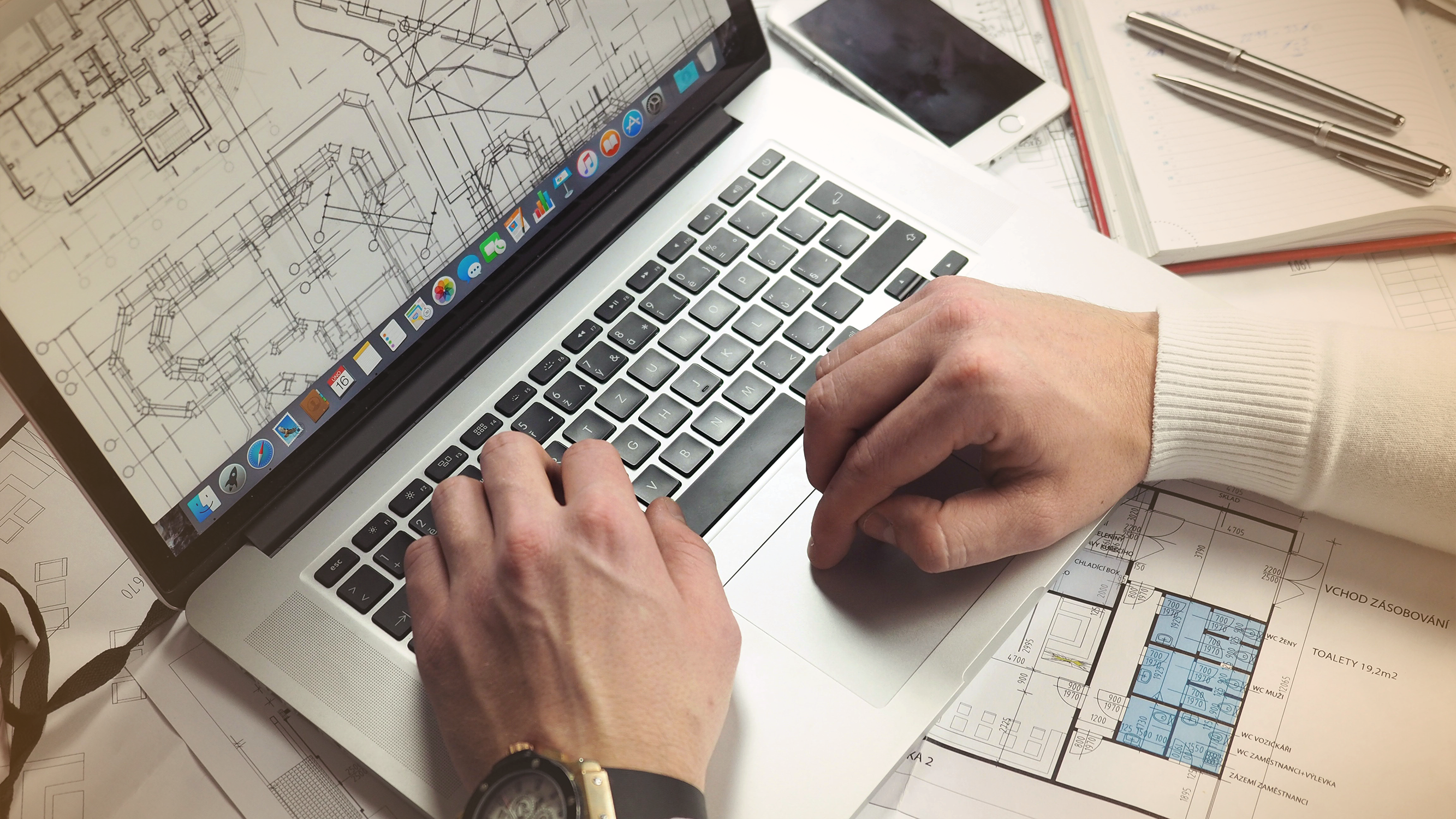 Man working on blueprints on a laptop