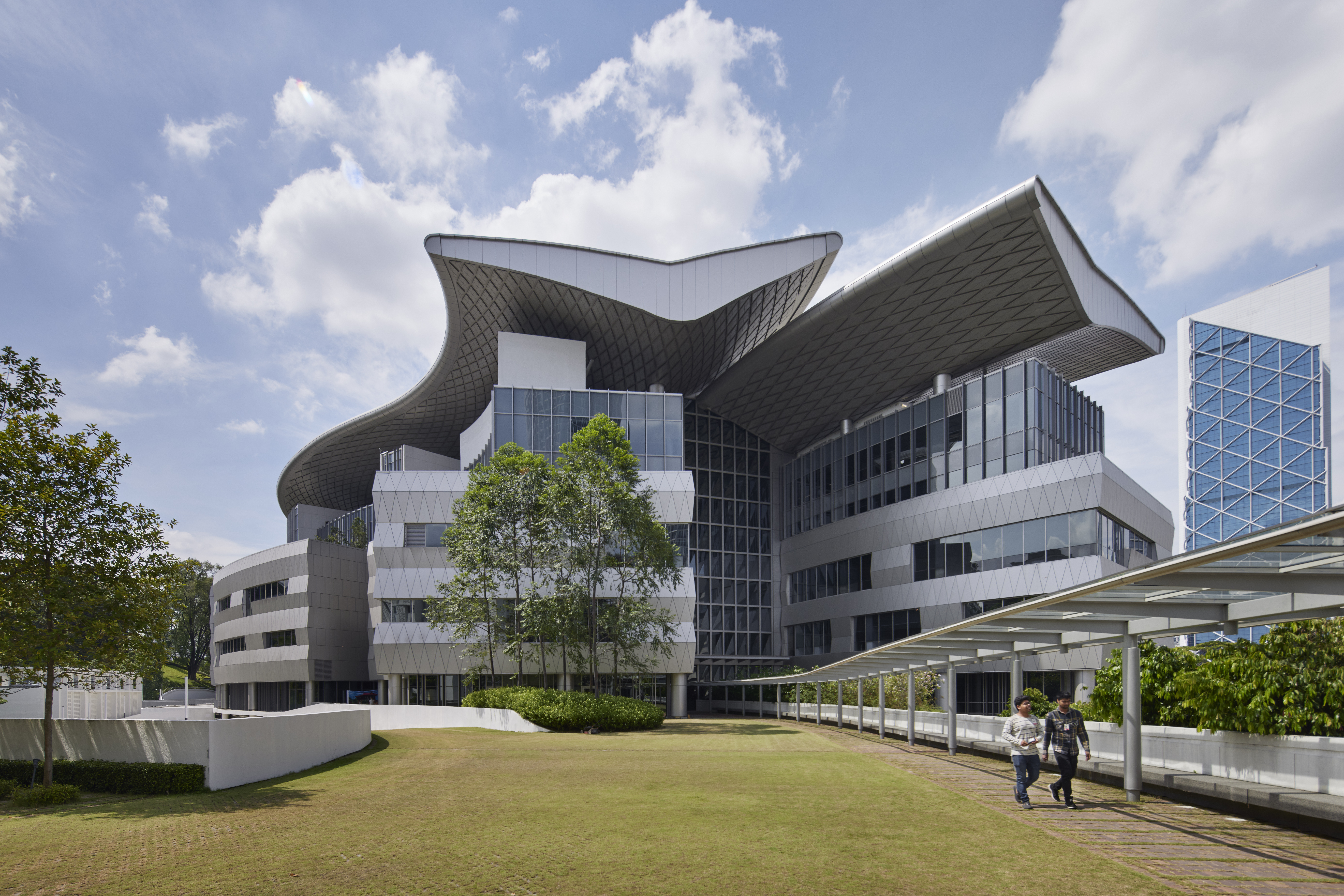 Asia School of Business Building Exterior Shot. Two people conversing and walking outside away from the building.