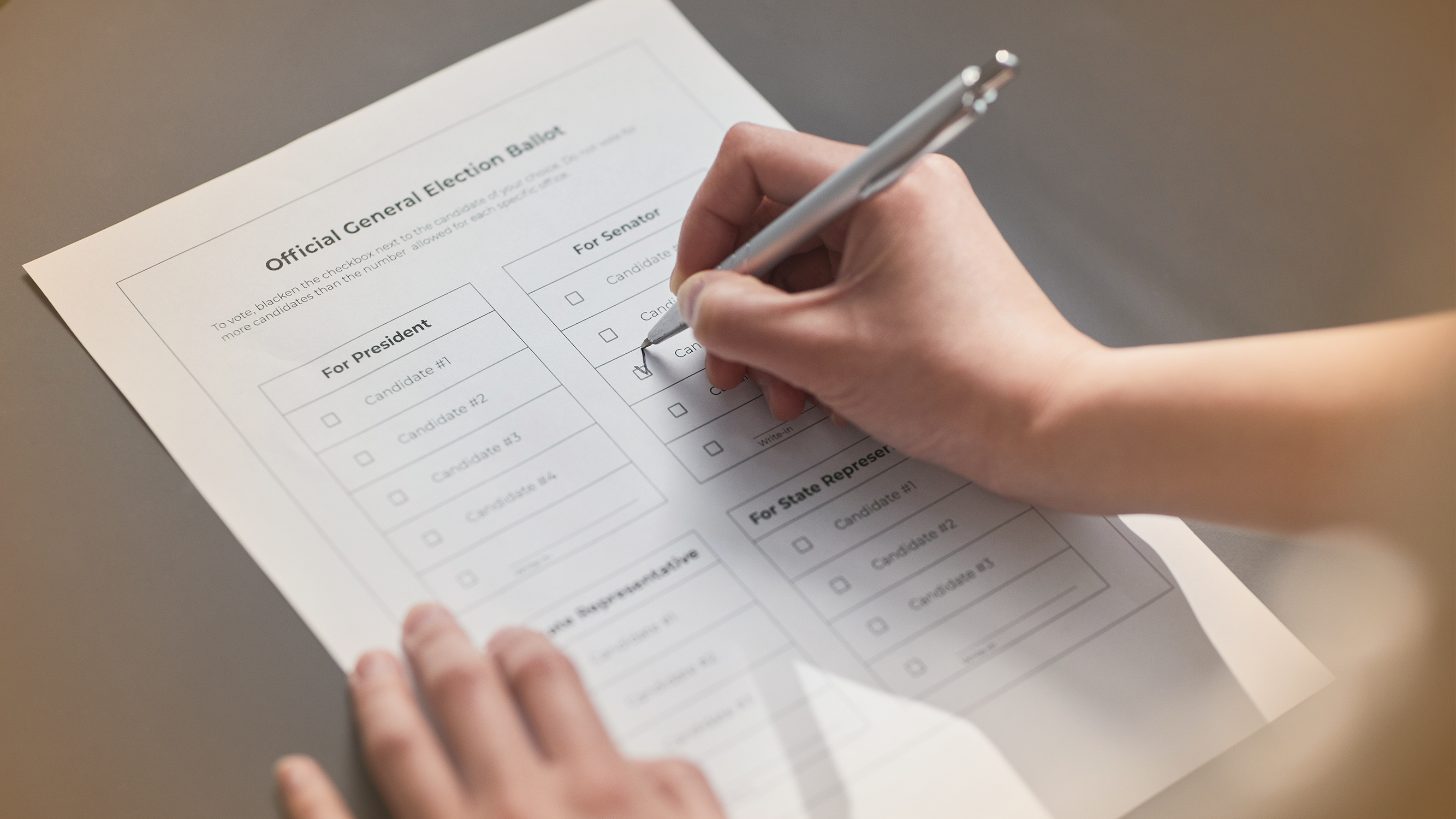 Close-up of person filling out election ballot.