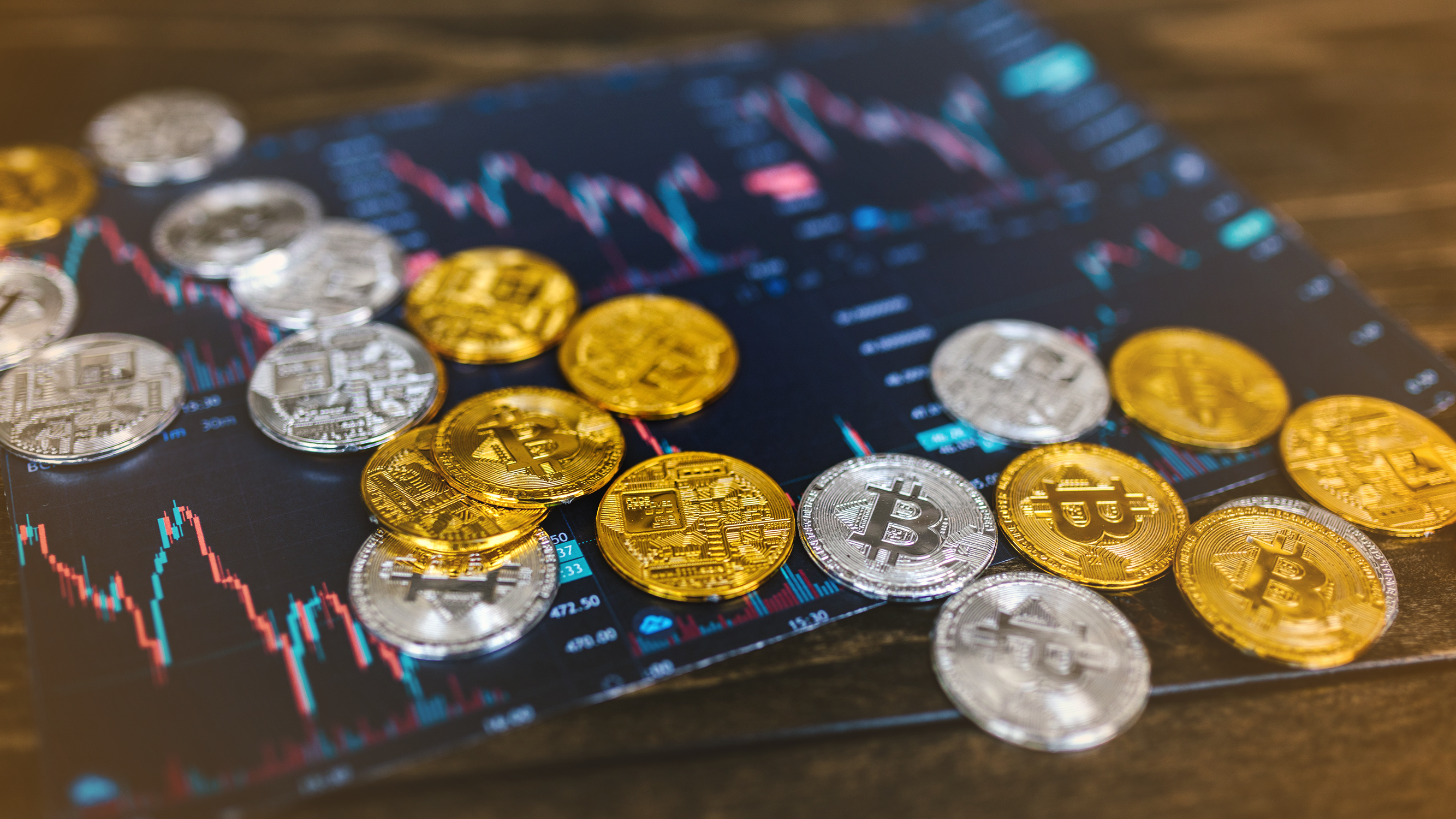 Cryptocurrency coins on a printout of stock trends, including bitcoin, ethereum, terra and solana