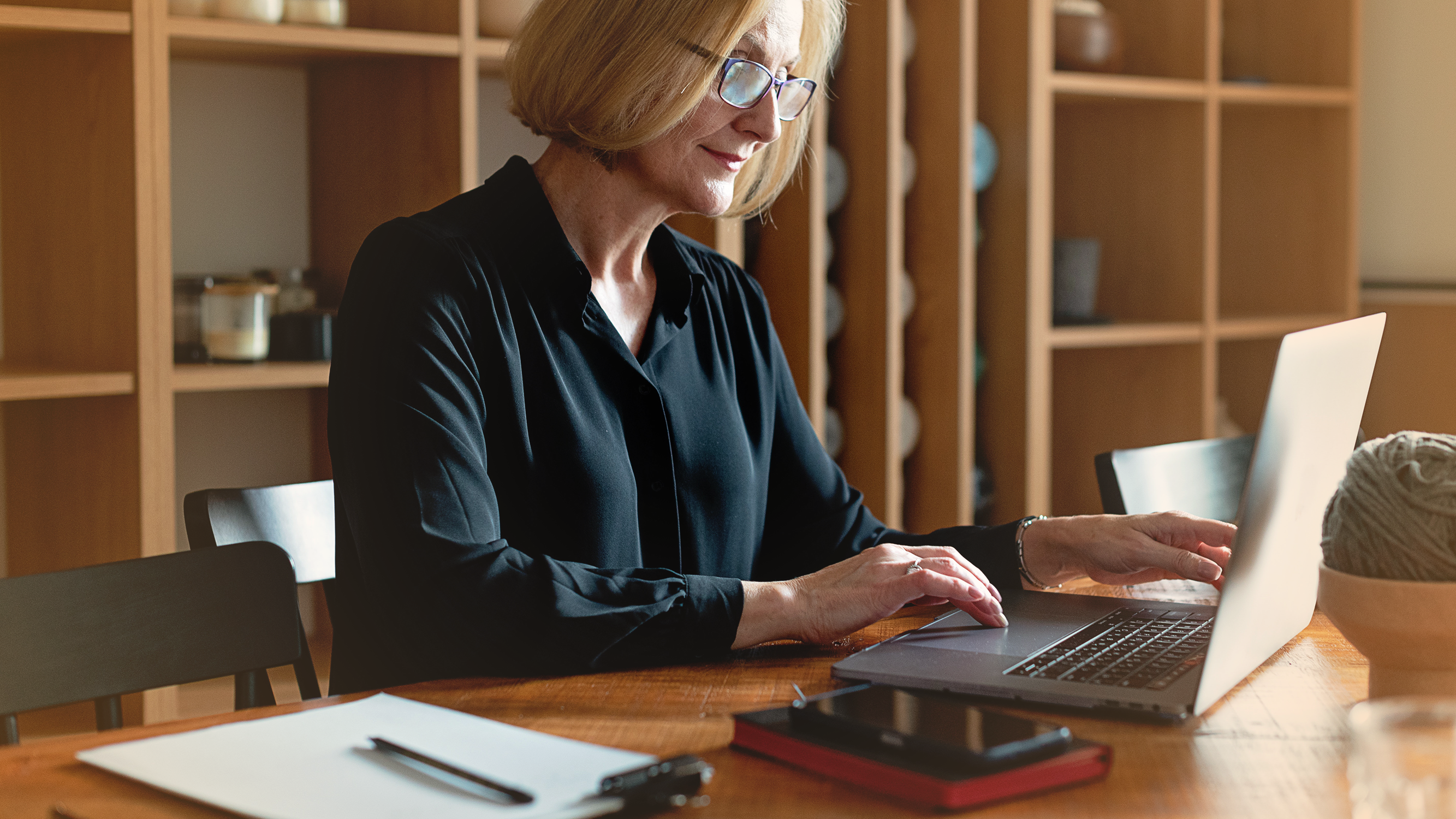 Woman looking at a laptop at a desk, work relating to credit supply