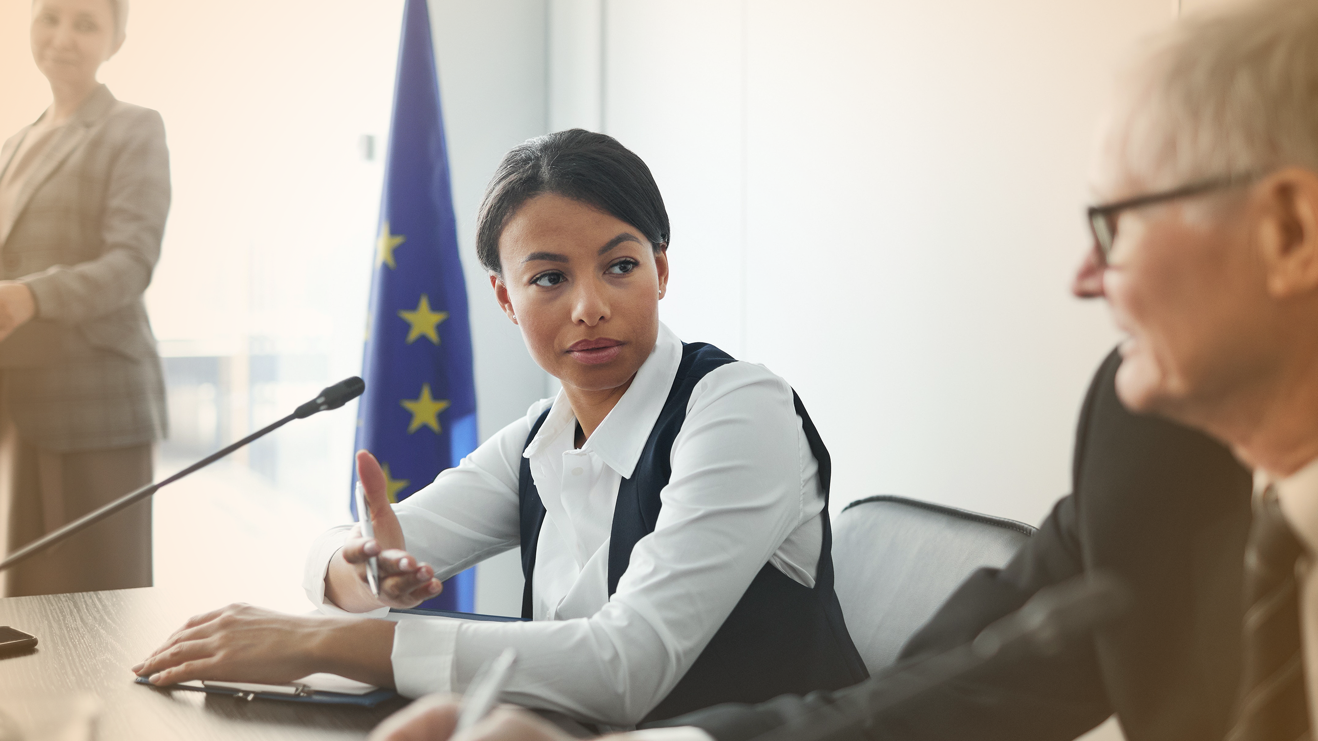 Woman and man in front of UN flag having conversation, relating to household loan and debt policy