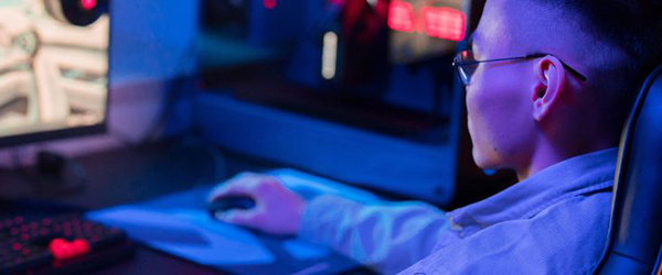 Individual sits in front of a computer playing games