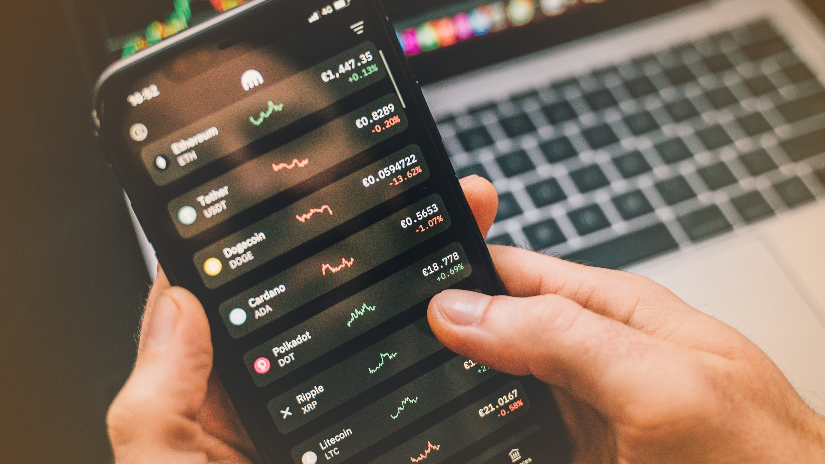 Person holding smartphone showing cryptocurrency stocks including ethereum, bitcoin and terra