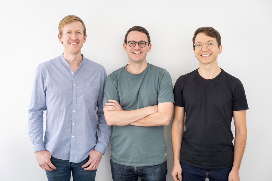 Three men pose together for a photo
