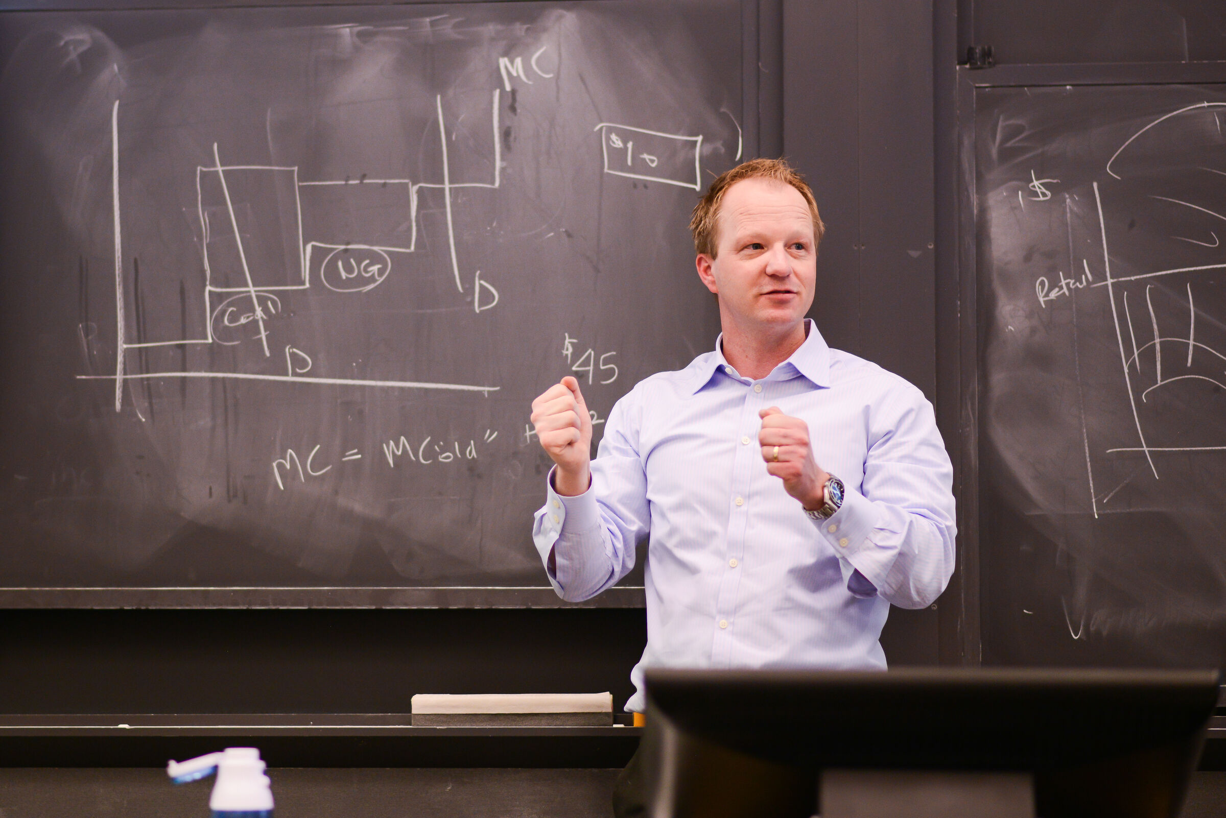 Professor stands in front of chalkboard