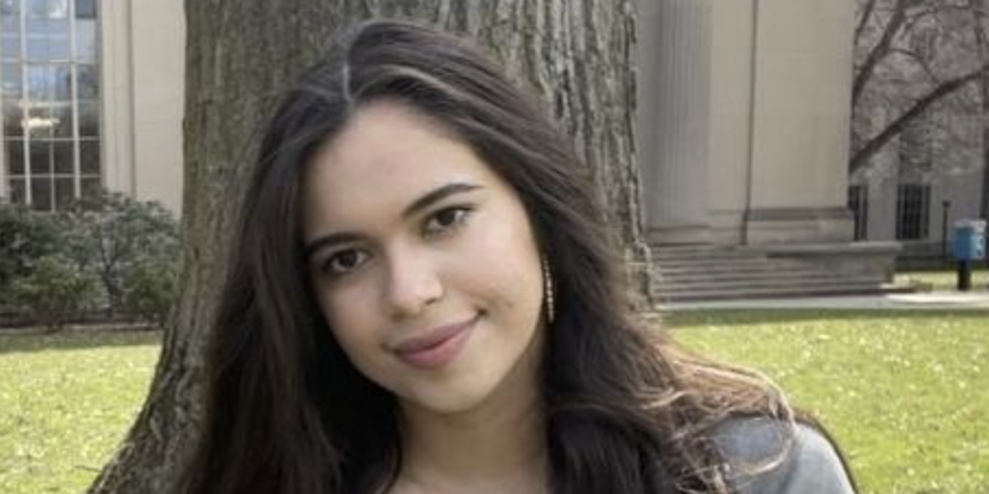 Young woman poses for a photo in front of MIT campus