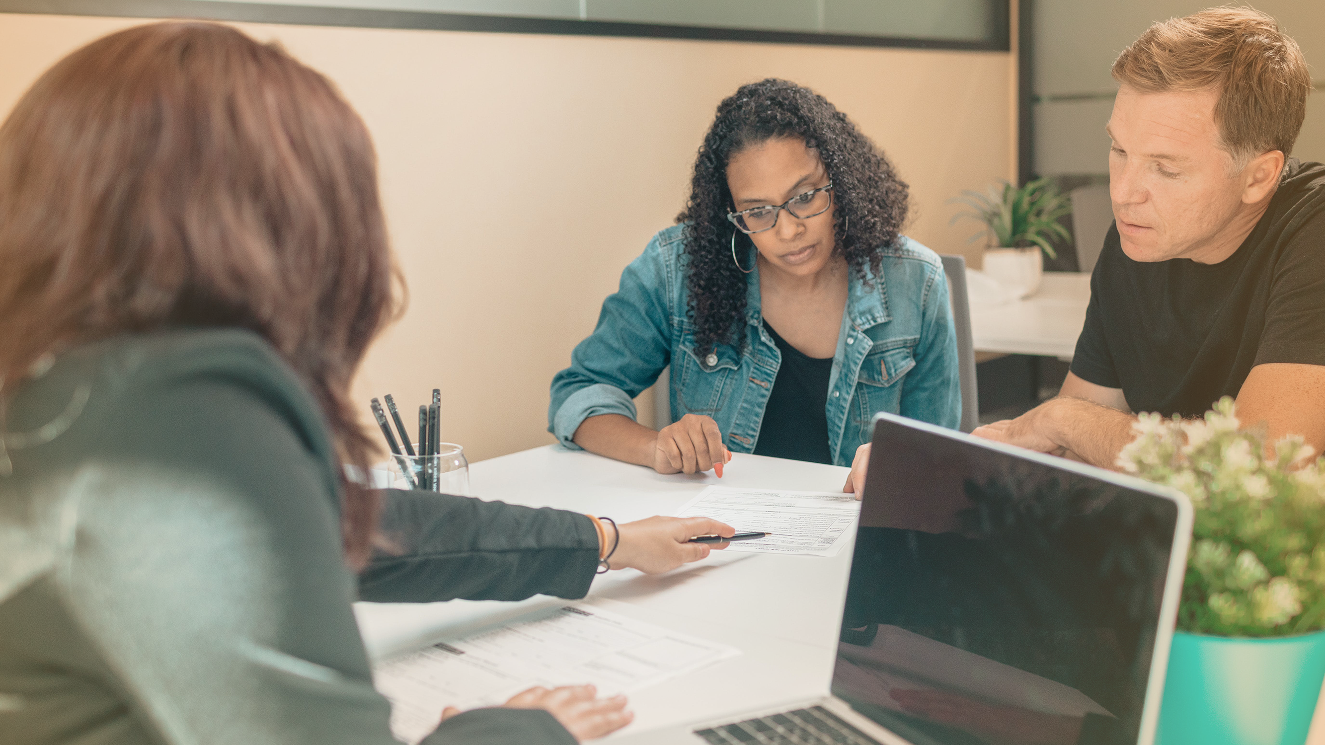 A couple reviewing paperwork with a financial advisor relating to bank lending standards and consumer loans