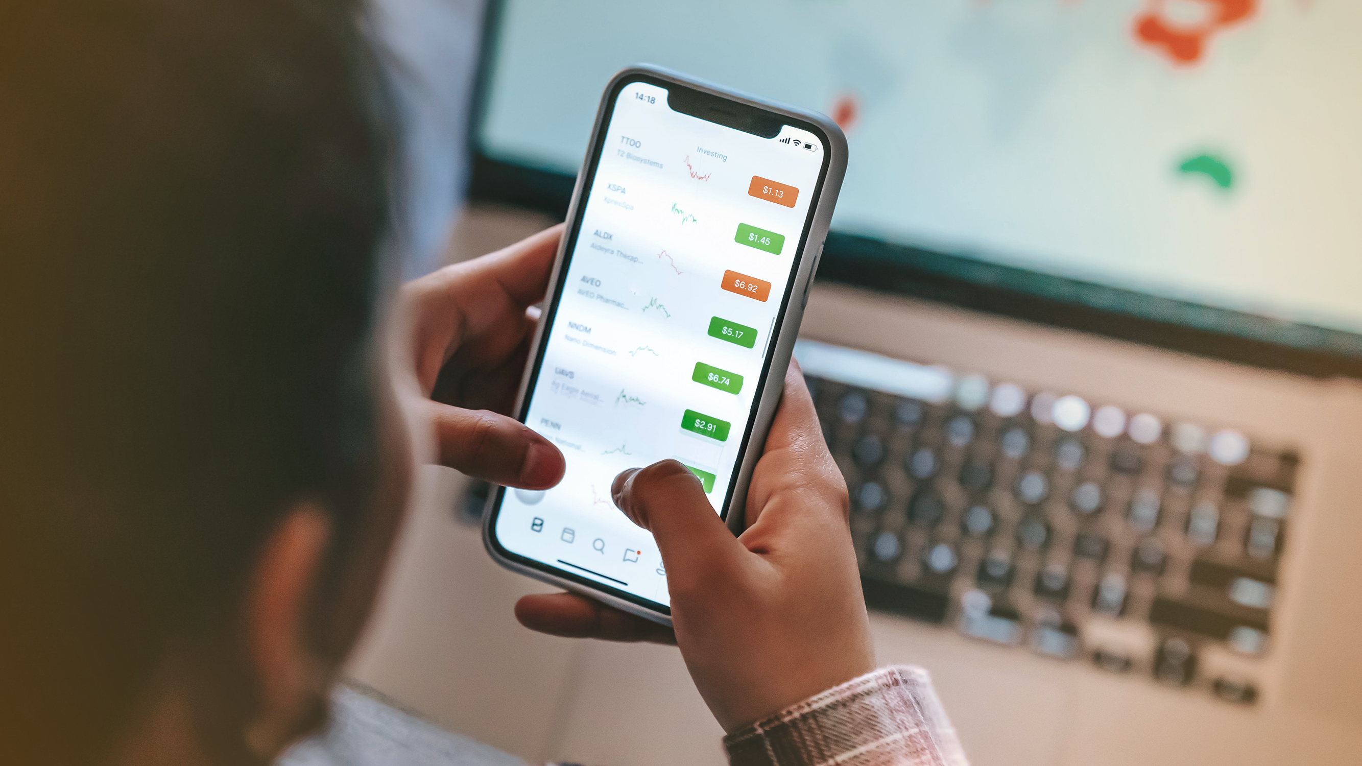 Person looking at stock updates on a smartphone relating to their target date funds