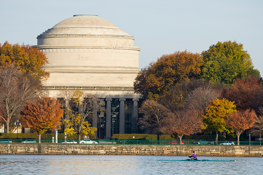 Rower moves across Charles River in front of MIT's Great Dome