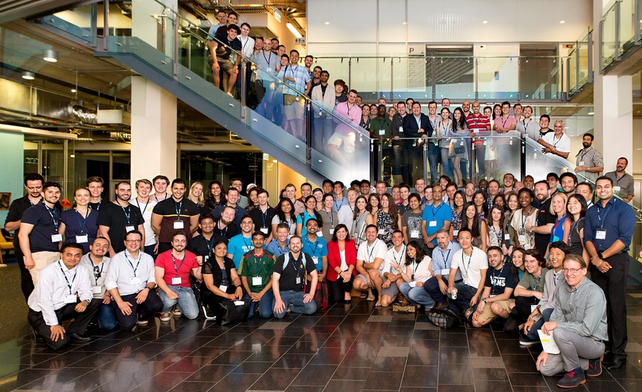 Large group poses for photo on and around staircase