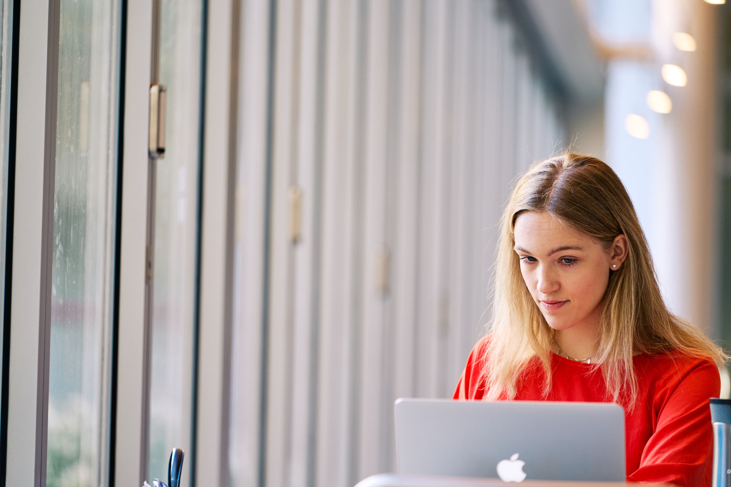 Student sits at her laptop in E62