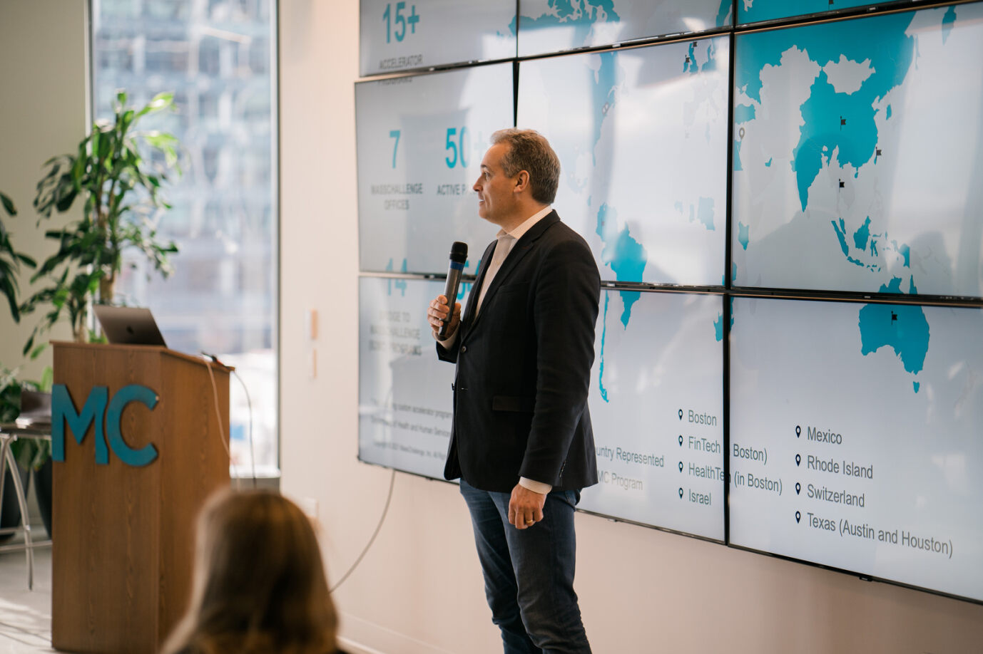 Phil Budden speaking in front of a world map on the wall