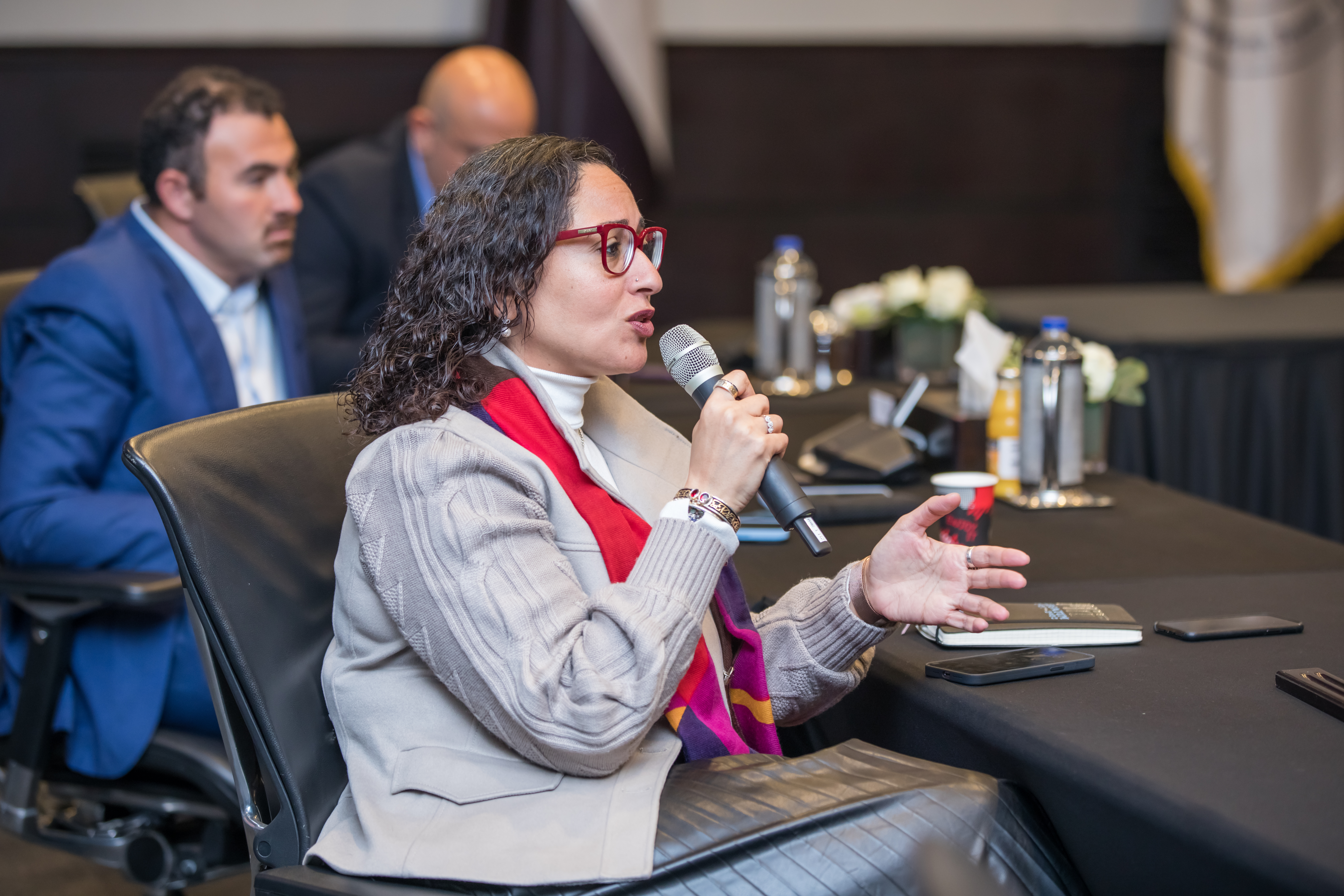 Seated woman asking a question using a microphone