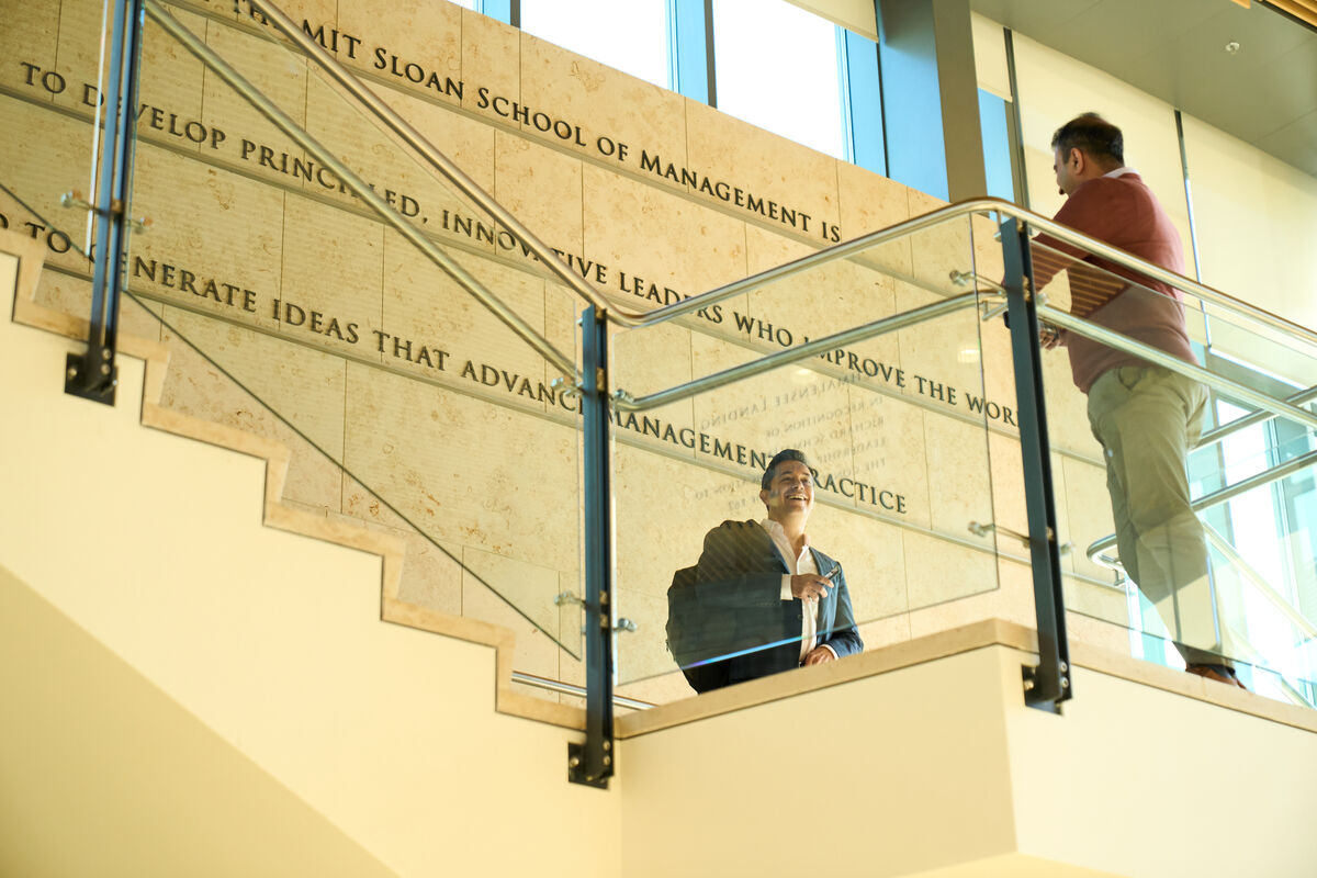 Students on staircase in E62 with MIT Sloan mission written on the wall in the background: THE MISSION The mission of the MIT Sloan School of Management is to develop principled, innovative leaders who improve the world and to generate ideas that advance management practice.