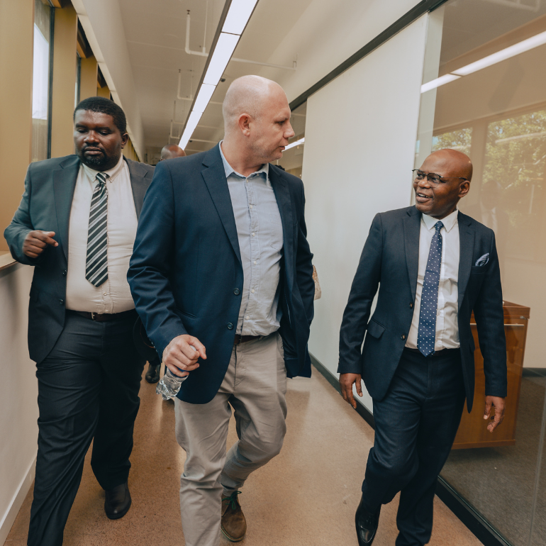 Action shot of three men walking down a hallway