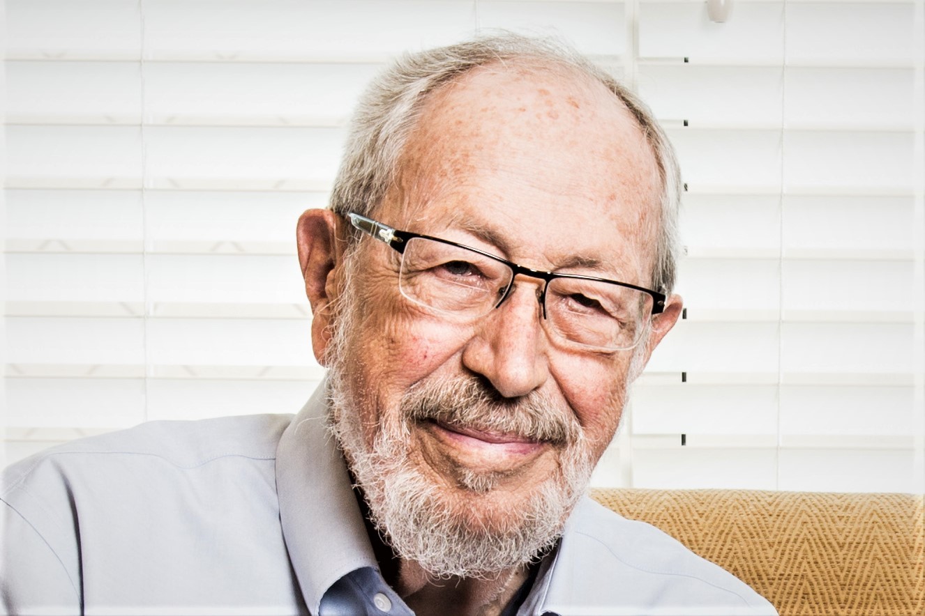A man with glasses and a beard smiling